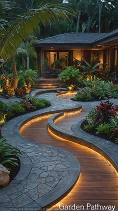 a garden path with lights in the middle and plants on either side, leading to a house