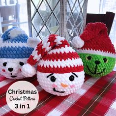 three crocheted snowman hats sitting on top of a red and white checkered table cloth