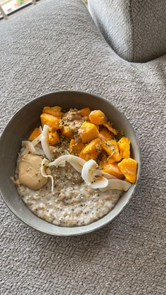 a bowl filled with oatmeal and fruit on top of a gray table