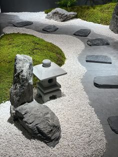 a garden with rocks, gravel and grass