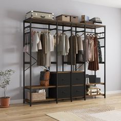 an open closet with clothes hanging on the rack and other items sitting on shelves in front of it