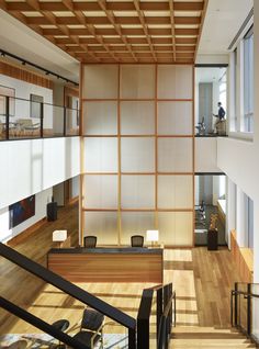 the interior of an office building with wood flooring and white walls, along with wooden staircases