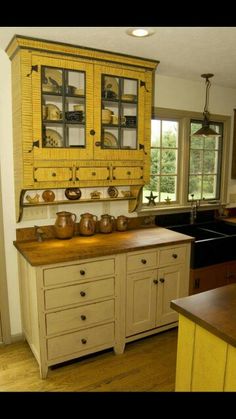 a kitchen with yellow cabinets and wooden counter tops