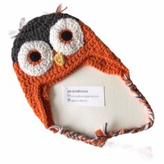 an orange and black crocheted owl hat