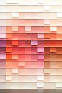 an abstract wall made up of squares and rectangles in shades of pink, orange, yellow and white