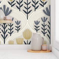 a white vase sitting on top of a counter next to a wallpapered wall