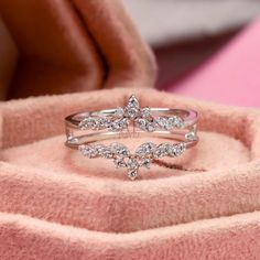 two diamond rings sitting on top of a pink blanket