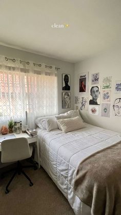 a white bed sitting in a bedroom next to a desk and window with pictures on the wall