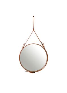 a round mirror hanging from a rope on a white wall