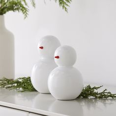 three white vases sitting on top of a counter