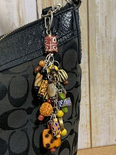 a handbag with charms hanging from it's side on top of a table