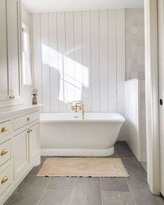 a white bath tub sitting inside of a bathroom