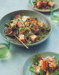 two plates with food on them sitting on a table next to some glasses and water