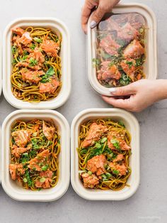 six plates of pasta with salmon and spinach in them being held by two hands