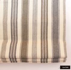 a close up of a striped curtain on a white wall with a black and brown stripe