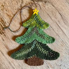 an ornament made to look like a christmas tree on a wooden table with string