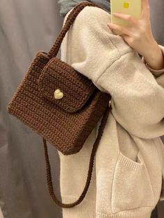 a woman holding a brown crocheted purse with the words descubra como aprrender crochet passo