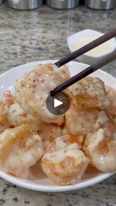 a white plate topped with meat covered in sauce and chopsticks