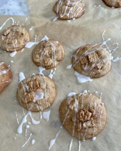 cookies with icing and nuts on top of parchment paper covered in white glaze