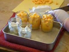 four jars filled with food sitting on top of a metal tray next to a person's hand