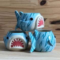 three ceramic shark mugs sitting next to each other