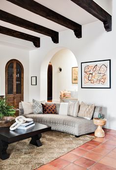 a living room filled with lots of furniture and decor on top of a rug covered floor