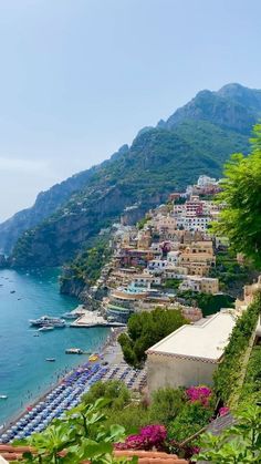 the beach is lined with umbrellas and parked cars on it's sides, along with mountains in the background