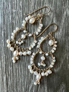 Beautiful intricate chandelier earrings in two or three tiered versions. Hand wrapped freshwater pearls in 14 karat gold filled wire make a dramatic statement. Two tiered version is 2.5 inches, three tiered version is 4 inches long. Handmade ear wires. BoHo brides - this is a wonderful earring for your wedding day. Artist is happy to make in rose gold filled wire or sterling silver. DM the shop owner with requests. Gold filled items contain significantly more gold than similar gold plated items allowing for daily wear without fear of tarnishing or damaging the finish. Elegant Hand Wrapped Dangle Jewelry, Wire Wrapped Dangle Chandelier Earrings For Wedding, Elegant Wire Wrapped Chandelier Earrings For Wedding, Elegant Hand Wrapped Dangle Earrings, Elegant Hand Wrapped Drop Earrings, Elegant Hand Wrapped Gold Earrings, Wire Earrings Handmade, Pearl Chandelier Earrings, Asymmetrical Earrings