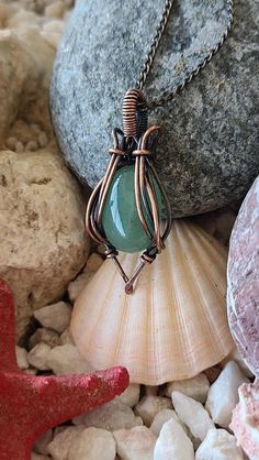 Product Title: Handcrafted Natural Aventurine Pendant - Copper Wire Wrap Design  Product Description: This unique and elegant pendant features a captivating Aventurine , a true gem of nature's beauty. The stone is intricately wrapped with copper wire, accentuating its natural sparkle. Each pendant is handcrafted, making it the perfect accessory to add a touch of elegance to any outfit. Due to the natural properties of the stone, each piece is one of a kind, ensuring your necklace is as unique as Aventurine Gemstone Jewelry For Meditation, Aventurine Jewelry With Natural Stones In Round Pendant, Aventurine Natural Stones Amulet Jewelry, Aventurine Amulet With Natural Stones, Healing Aventurine Round Pendant Jewelry, Aventurine Round Pendant Gemstone Jewelry, Aventurine Gemstone Round Pendant Jewelry, Aventurine Gemstone Pendant Jewelry, Green Aventurine Amulet Jewelry