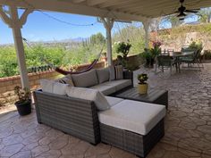 a covered patio with furniture and plants on it