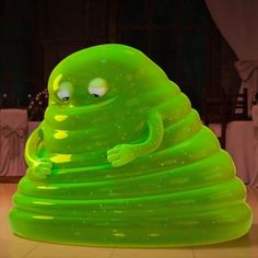 an inflatable green creature sitting on top of a table