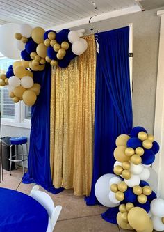 blue and gold balloons are hanging from the ceiling