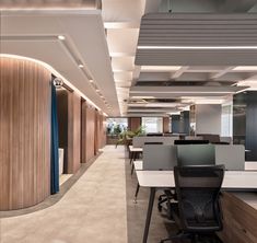 an empty office with desks and chairs in the center, along with wood paneling on the walls