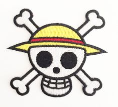 a patch with a skull wearing a yellow hat and crossbones on it's side