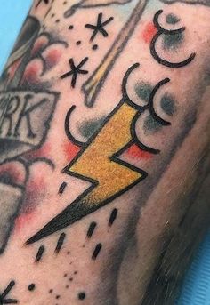 a close up of a person's arm with tattoos on it and lightning bolt