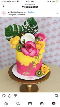 a pink and yellow cake with flowers on top