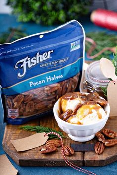 pecan halves in a bowl on a cutting board next to a bag of fisher chef's naturals