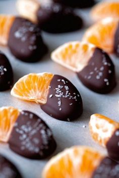 orange slices and chocolate covered candies are arranged on a baking sheet