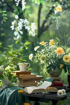 a table topped with books and vases filled with flowers