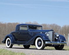 an antique car is parked on the side of the road