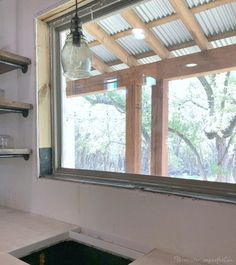 an unfinished kitchen with open shelves and a window