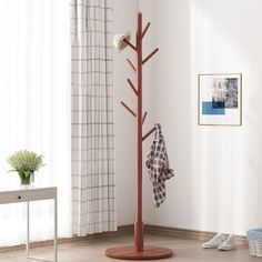 a coat rack with two coats hanging from it's sides in a living room