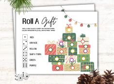 a roll a gift game with dices and christmas presents on it next to a pine cone