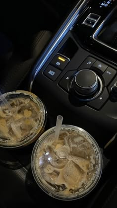 two drinks sitting on top of a table in front of a car stereo and control panel