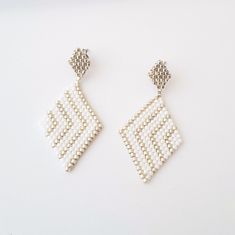 Rhombus white woven earrings. Here are some delicate stud earrings made with Miyuki beads and completely hand-woven by me. Delicate Rhombus shaped earrings, with Miyuki beads in white and silver colors. Refined and very light to wear. The base that holds the earring is in stainless steel. Features of the earrings are: Length: 4.5cm Width: 2.3cm Here you can see other designs of white, gold and silver earrings: https://www.etsy.com/shop/AQBijouterie?ref=seller-platform-mcnav&section_id=34429251 Elegant Geometric White Jewelry, Elegant White Geometric Jewelry, Handmade White Beaded Rectangular Earrings, Handmade White Rectangular Beaded Earrings, Gold And Silver Earrings, Woven Earrings, Rhombus Shape, Beaded Earrings Patterns, Miyuki Beads