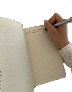 a person holding a pen and writing on a notebook with lined paper in front of them