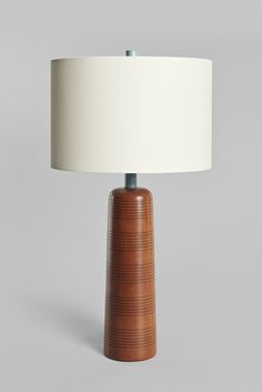 a wooden table lamp with a white shade