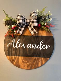 a wooden sign with the word alexandria on it and some flowers in front of it