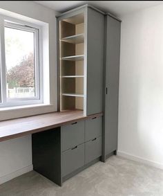 an empty room with a desk and shelves