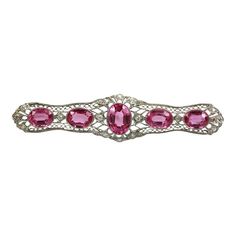 This is part of Chairish’s Fine Jewelry assortment.  WEIGHT: 10.9 grams STONES: 5 pink synthetic sapphires; 16 diamonds, clarity SI2, color H METAL: 18k white gold and platinum SIZE: 2 7/8″ long  Pink Sapphire & Platinum Deco Brooch Diamonds. This brooch is made with synthetic pink sapphires and is absolutely beautiful. It is made of platinum with a 18k white gold clasp. There are 16 small diamonds and 5.56 carats of faux sapphires. This lovely piece also looks stunning when worn on a chain (cha Luxury Pink Brooch For Wedding, Luxury Pink Brooches For Wedding, Luxury Pink Wedding Brooches, Luxury Pink Brooch Jewelry, Pink Sapphire, Platinum, Sapphire, Fine Jewelry, Size 2